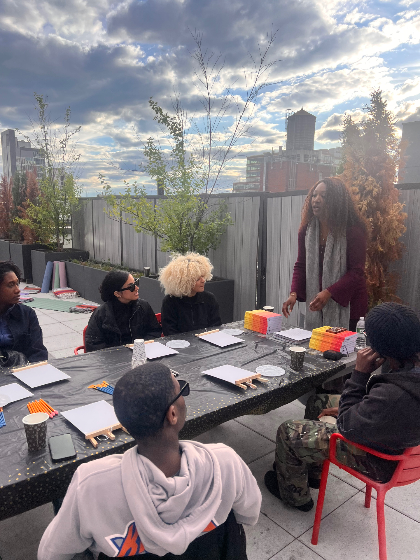 Facilitator leading a circle conversation at a rooftop wellness gathering